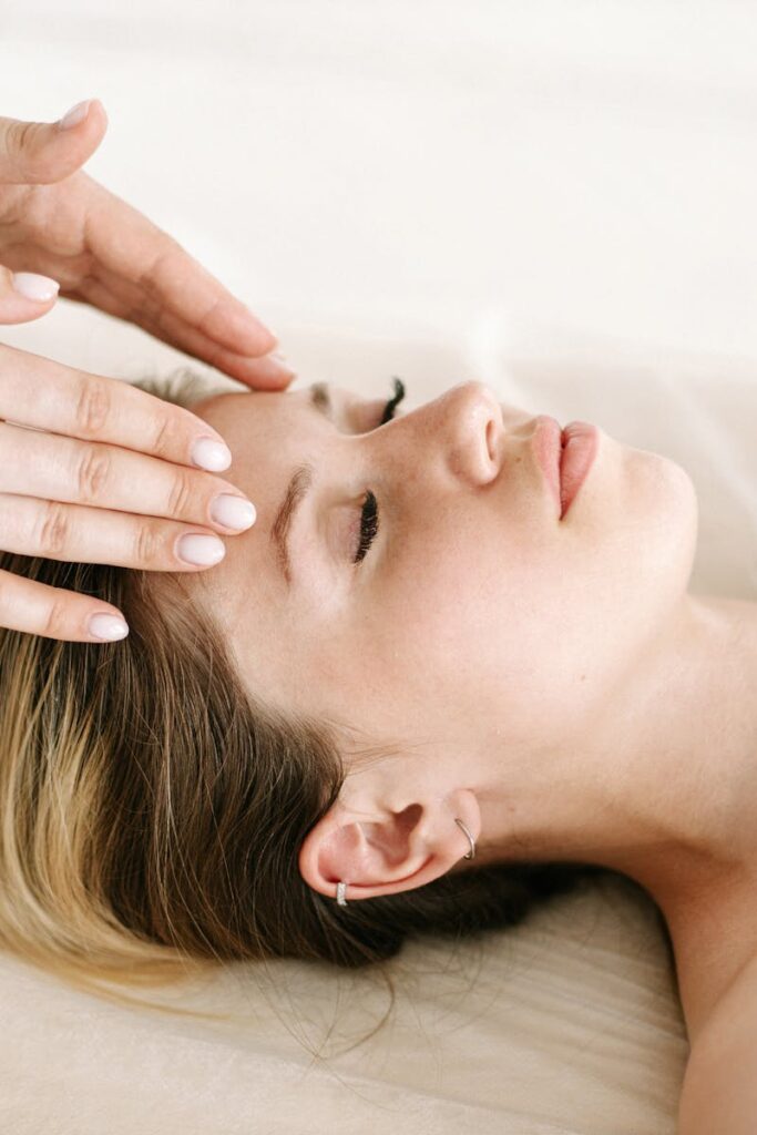 A woman enjoying a relaxing face massage at a spa for therapeutic benefits.